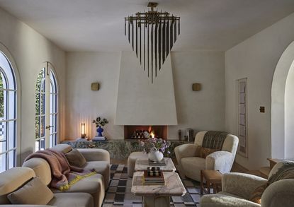 a large living room with a fireplace hearth, multiple seats and a large sculptural pendant light