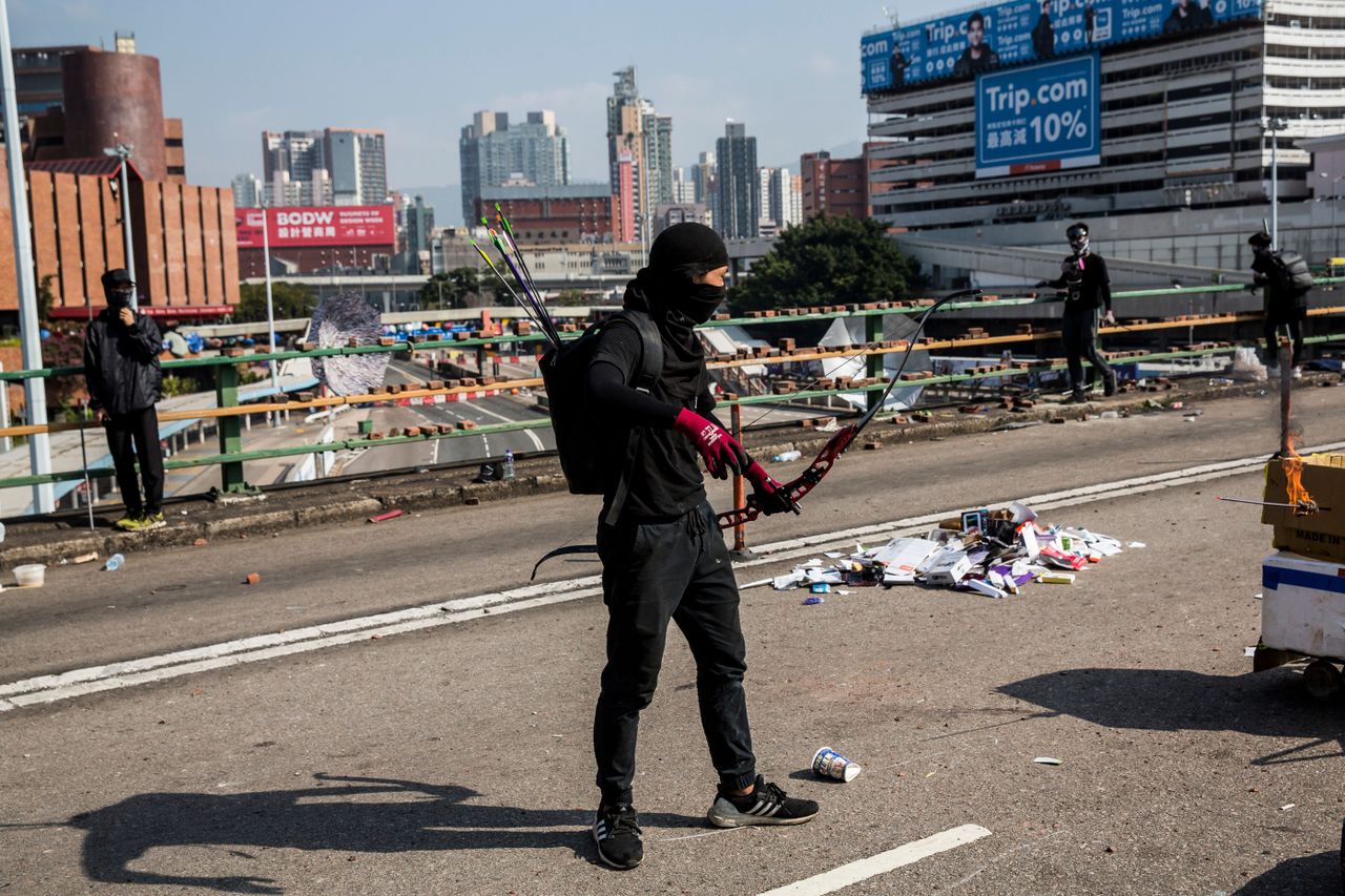 A protester with a bow and arrows stands on a barricaded street outside The Hong Kong Polytechnic University in Hong Kong on November 15, 2019. - Pro-democracy protesters challenging China&amp;#039;s 