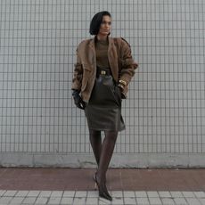 a woman in a brown leather jacket