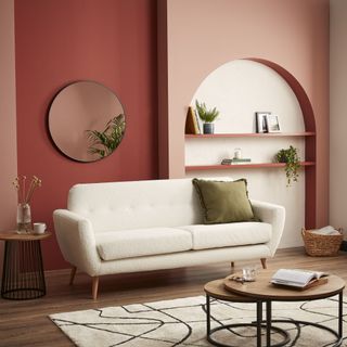 walls in different shades of pink with white alcove, with white sofa in front