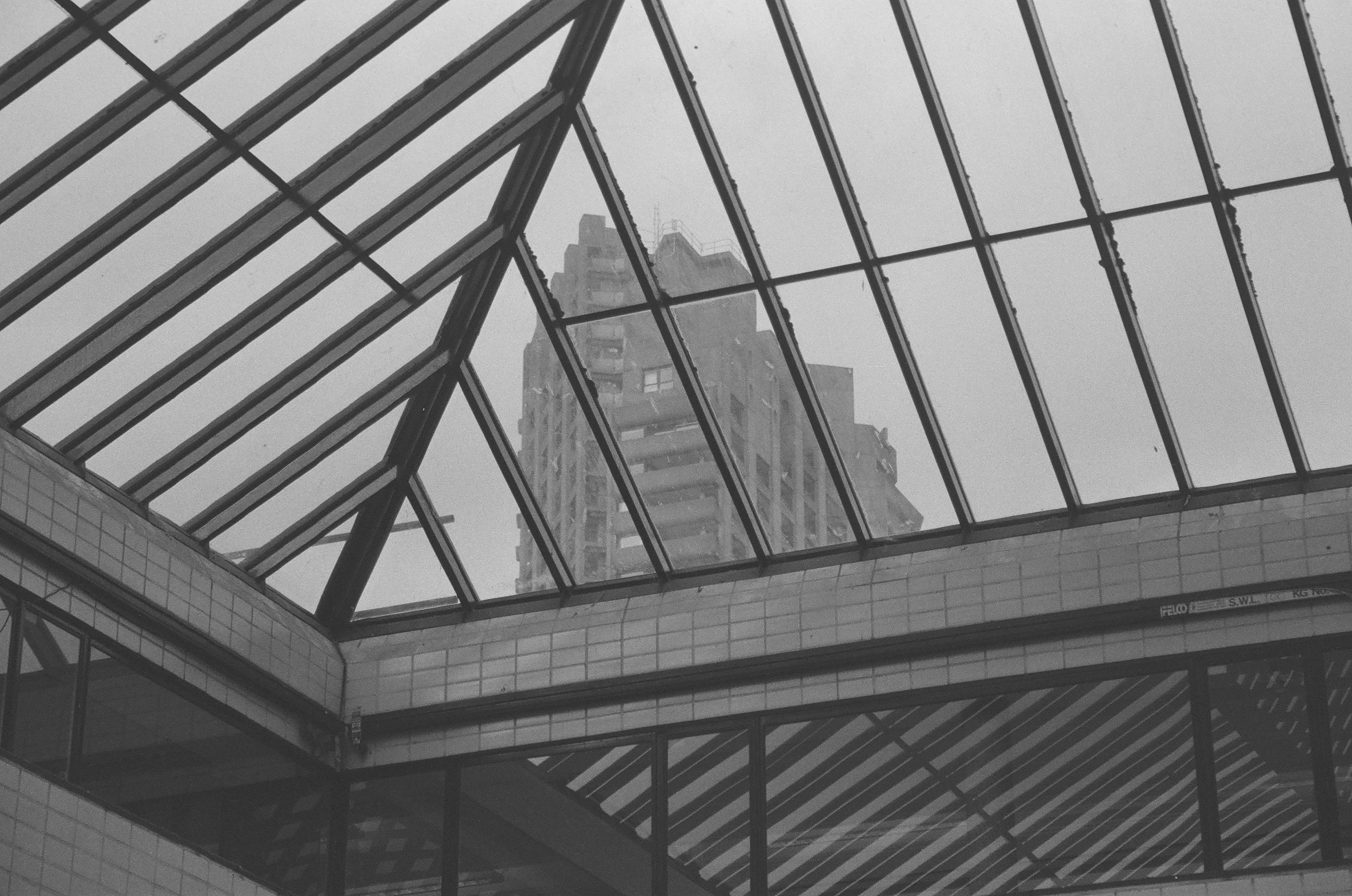 Sample photo of AgfaPhoto APX 400 35mm film showing the Barbican Cromwell Tower visible through a barred glass roof of another building.