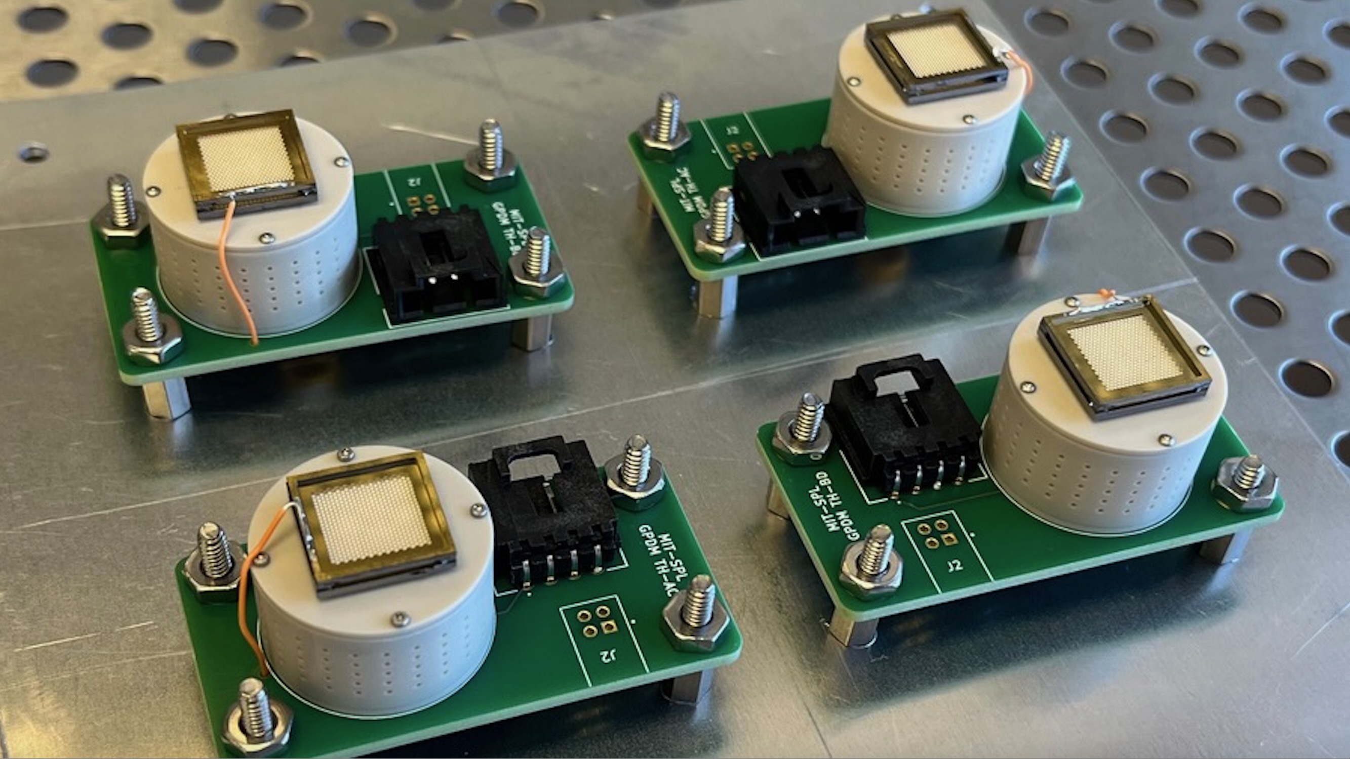 closeup of four rectangular green circuit boards on a metallic surface