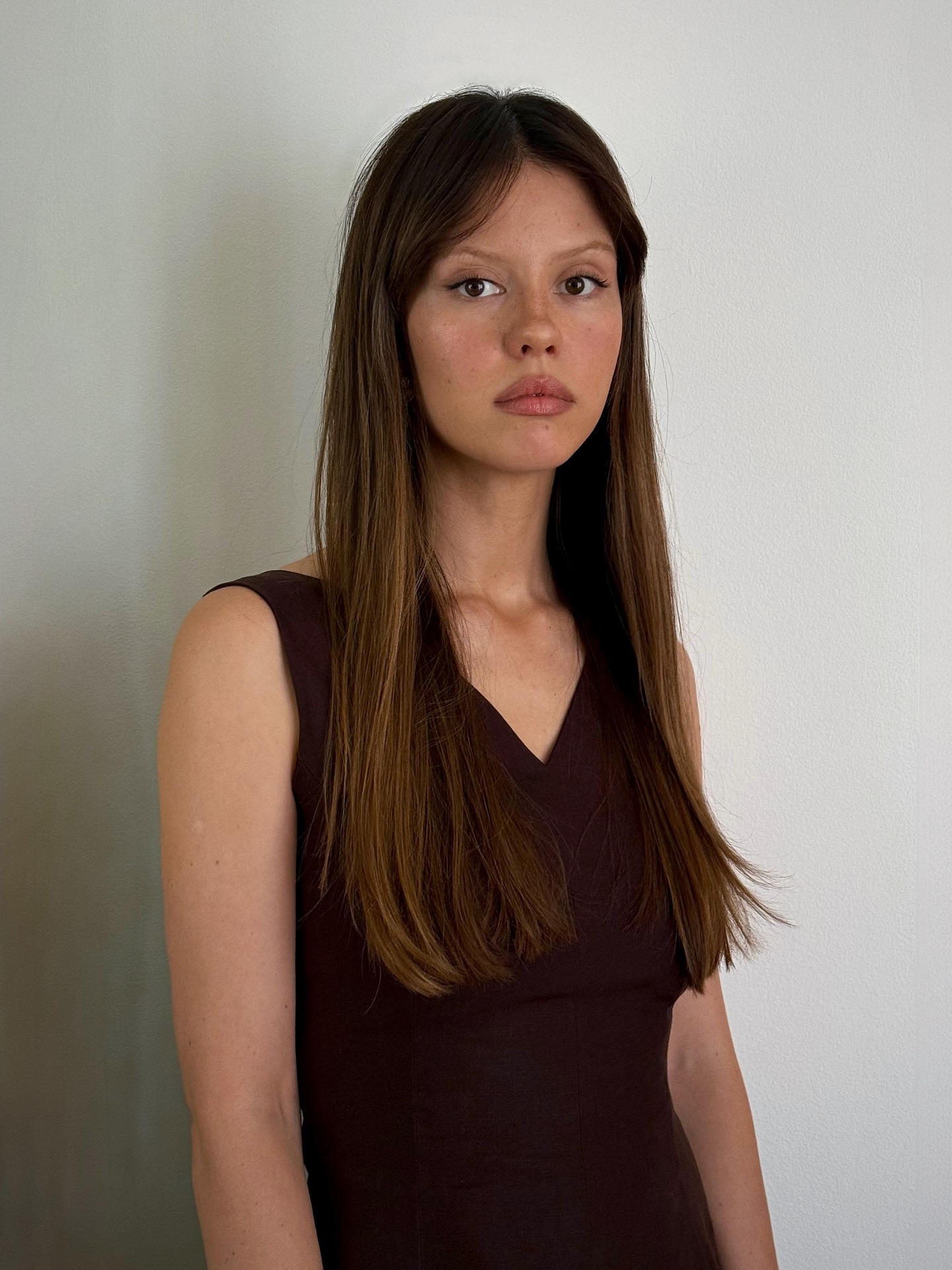Mia Goth with dark hair and subtle highlights