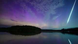Purple and blue patterns dot the sky over a reflective surface with a streak of light running down the right side