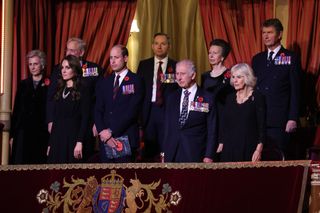 The Duchess of Gloucester, Kate Middleton, Prince William, King Charles, Queen Camilla, Timothy Laurence, Princess Anne all wearing black and standing in a balcony at the 2023 Festival of Remembrance