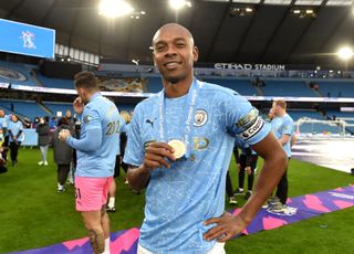 Manchester City captain Fernandinho celebrates with his Premier League winner's medal, 2021