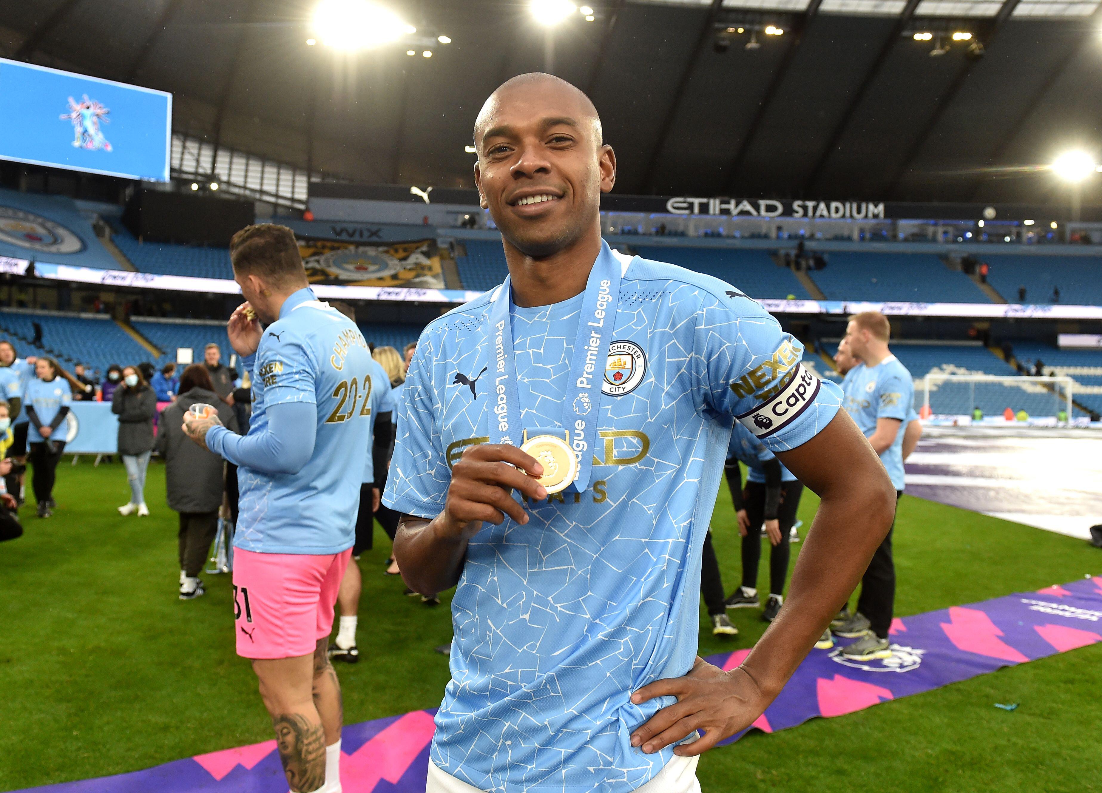 Manchester City captain Fernandinho celebrates with his Premier League winner's medal, 2021