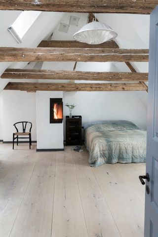 simple rustic bedroom with fireplace and exposed beams