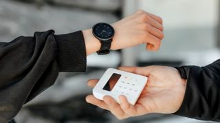 Someone making a payment using the wristband form a Polar smartwatch