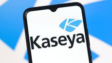 Kaseya company logo pictured on a smartphone screen with company branding blurred in background.