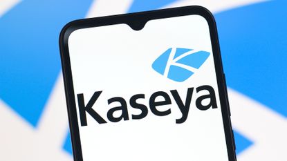Kaseya company logo pictured on a smartphone screen with company branding blurred in background.