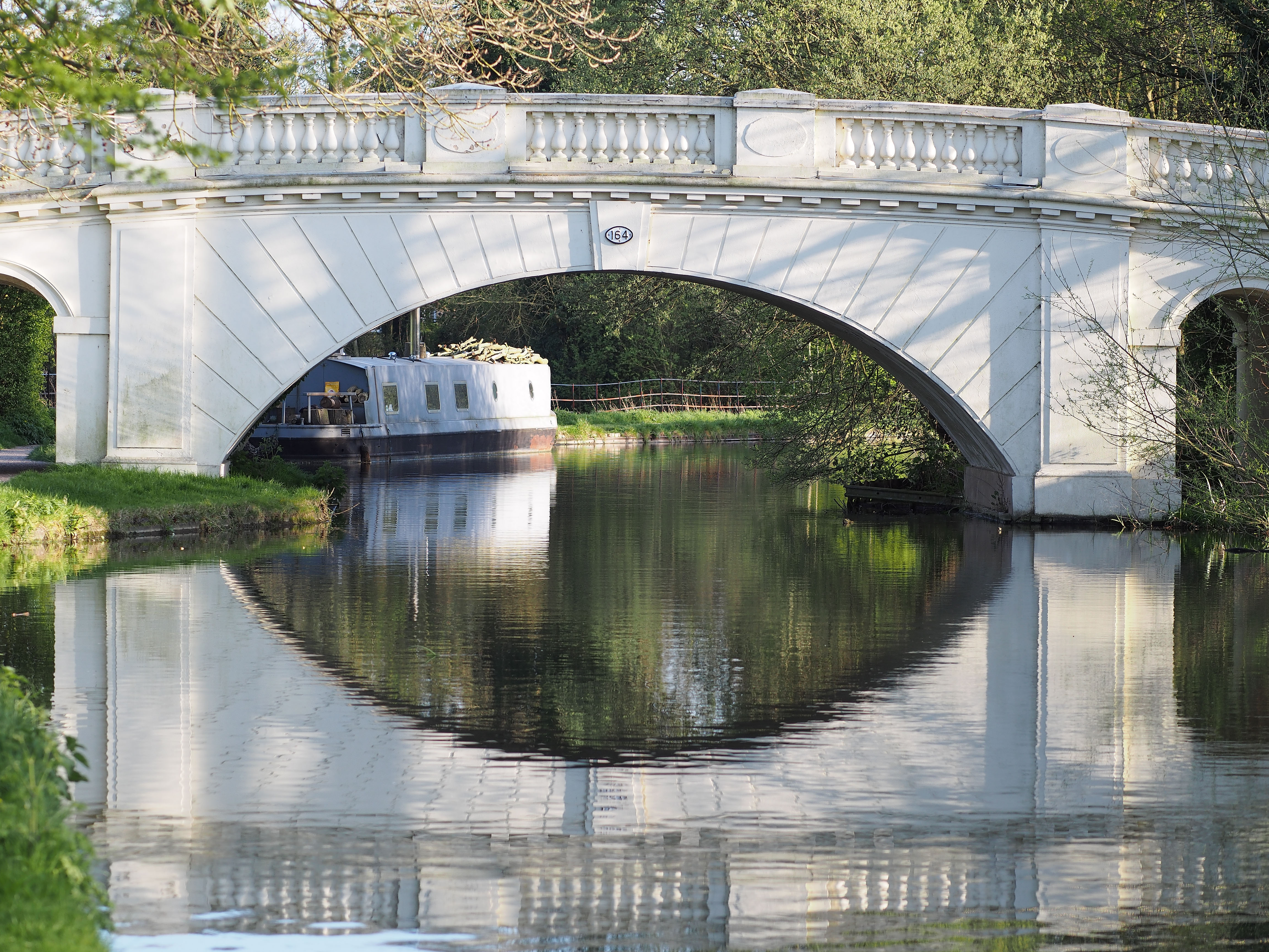 A white bridge over the Grand Union Canal.