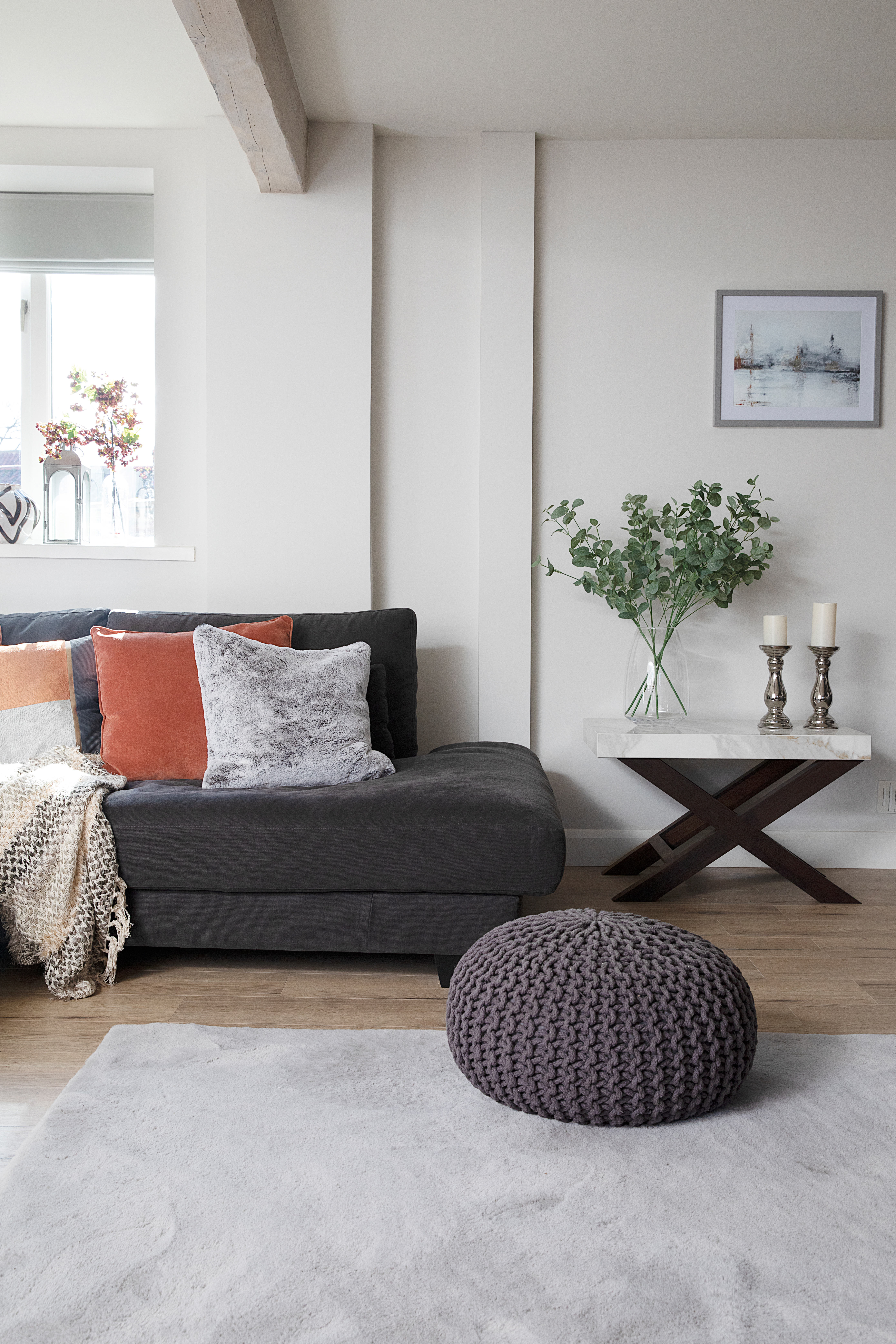 Grey and white living room with orange cushions