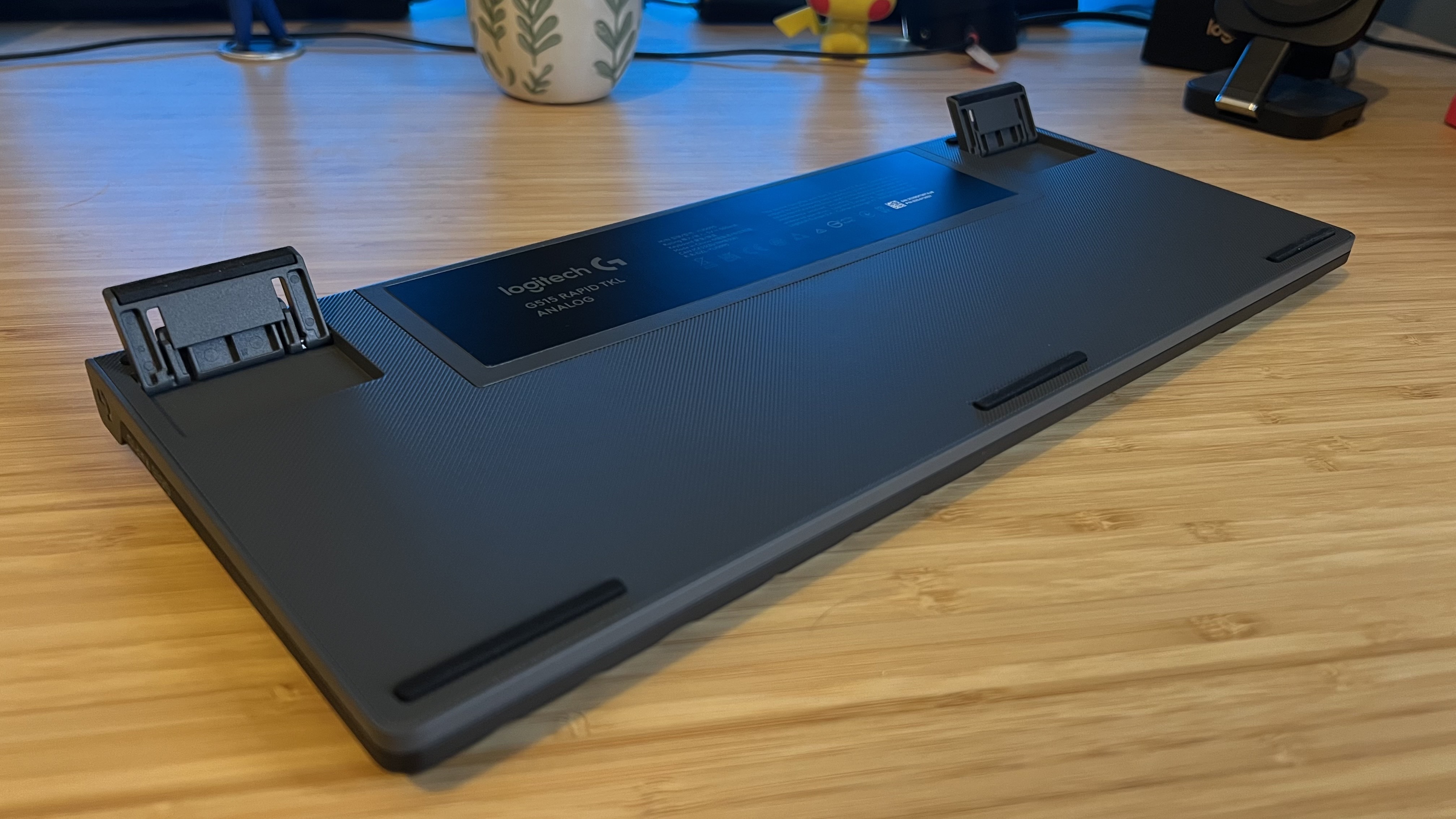 Underside of Logitech G515 Rapid TKL gaming keyboard with elevation feet extended