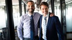 Two young, confident businessmen in an office corridor