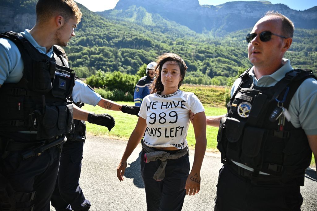 French gendarmes remove environmental protestors from the race route as their protest action temporarily immobilized the pack of riders during the 10th stage of the 109th edition of the Tour de France cycling race 1481 km between Morzine and Megeve in the French Alps on July 12 2022 Photo by Marco BERTORELLO AFP Photo by MARCO BERTORELLOAFP via Getty Images
