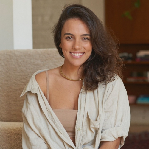 Image of a woman with brown hair in an off-white button down smiling