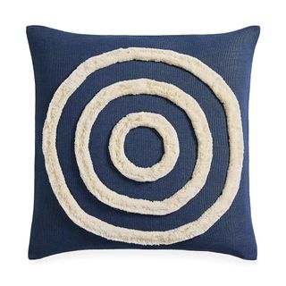 A dark blue and white pillow with a bull's eye pattern