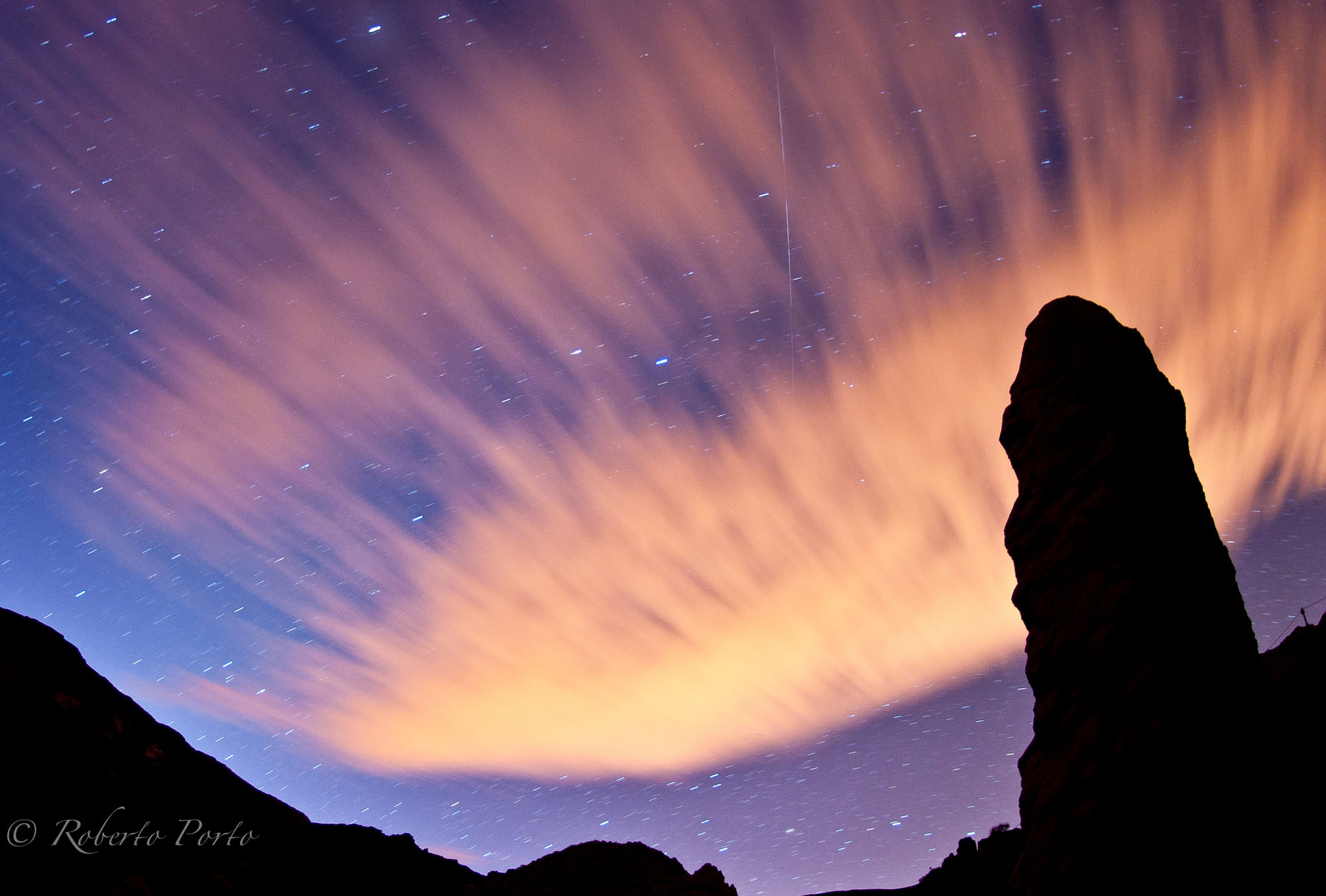 A Quadrantid meteor is seen streaking across a cloud-spattered sky with shadowy rocks in the foreground in this dazzling photo by astrophotographer Roberto Porto taken on Jan. 4, 2012 on Tenerife Island in Spain&#039;s Canary Islands during the meteor shower&#039;s