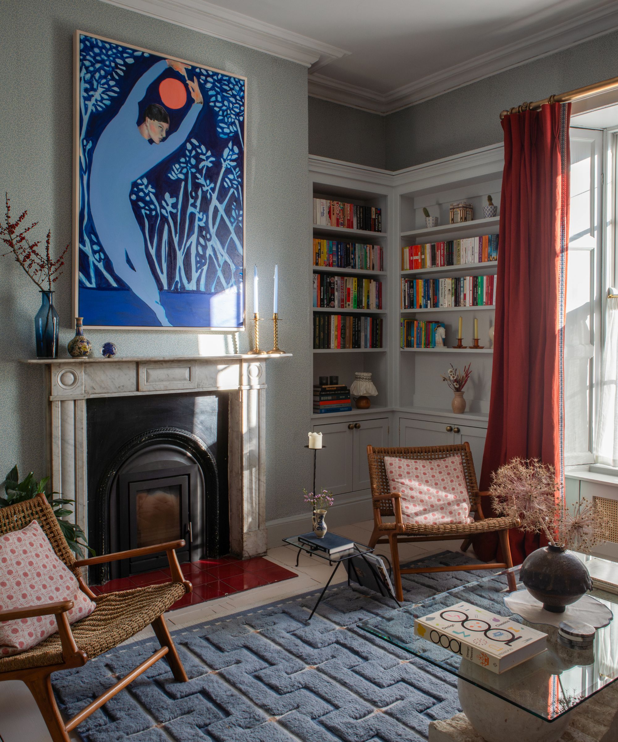 Pale blue/gray living room with marble fireplace and built in bookcases in one corner