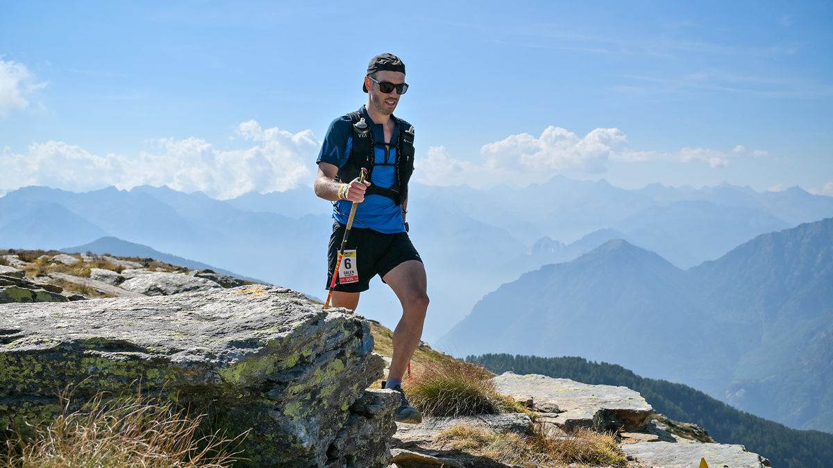 Ultra runner Galen Reynolds crosses a grassy hilltop.