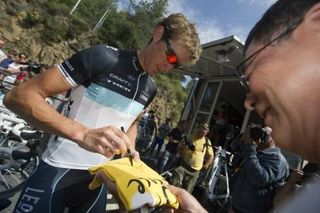 Luxembourg's Andy Schleck signs an autograph for a fan on a yellow jersey.