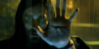 Michael Morbius (Jared Leto) holds his bleeding hand up to a window in 'Morbius'