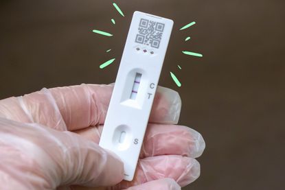 a close up of a positive covid test showing covid twice with annotated green rays around it