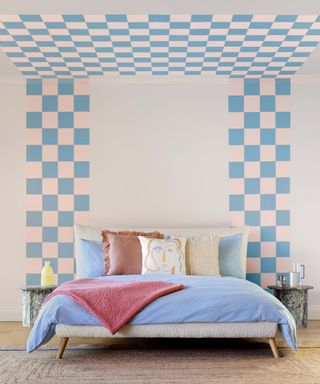 bedroom with checkered effect painted behind bed and onto ceiling