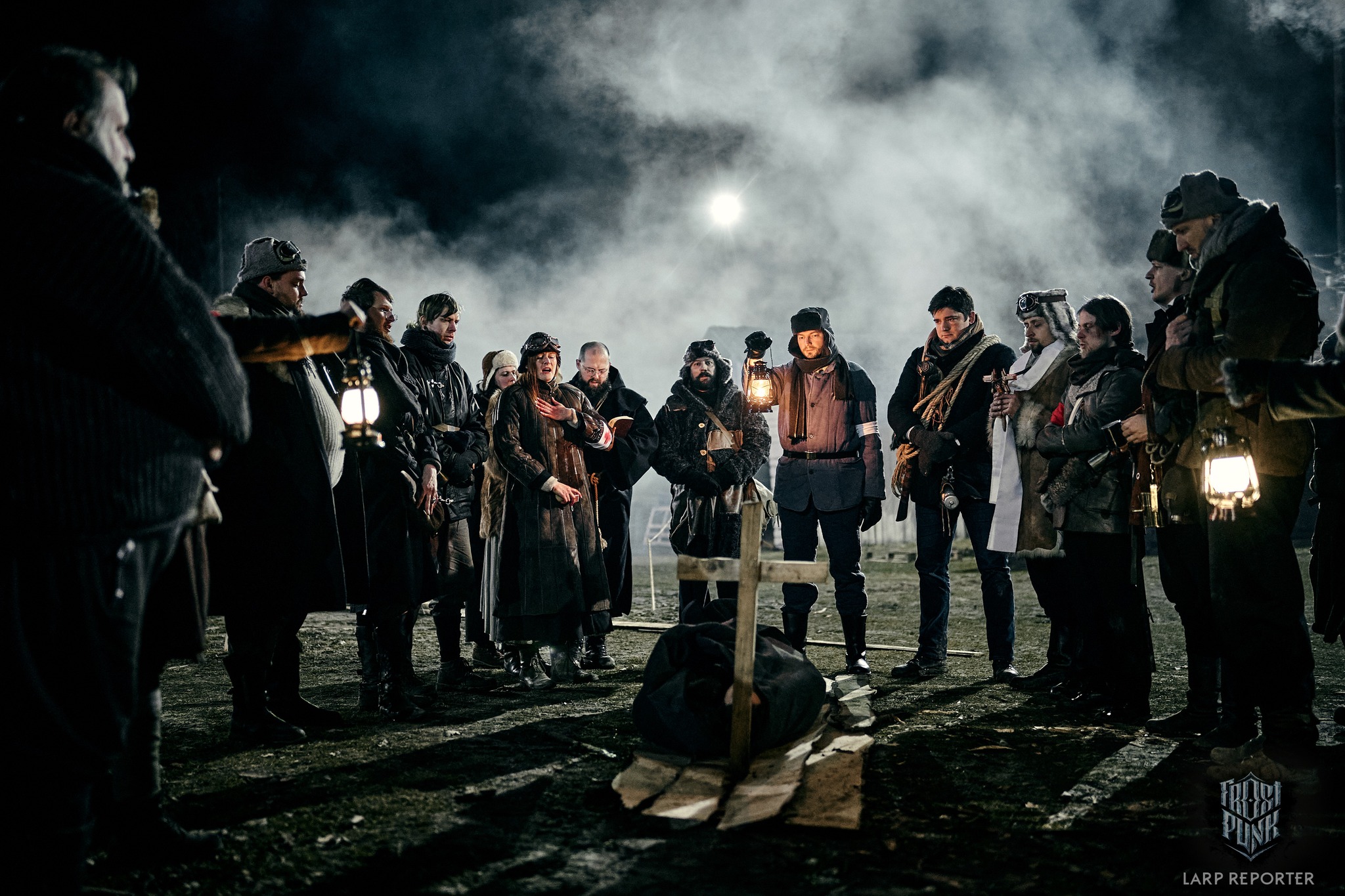 Group of people in Frostpunk garb stand around a makeshift grave.