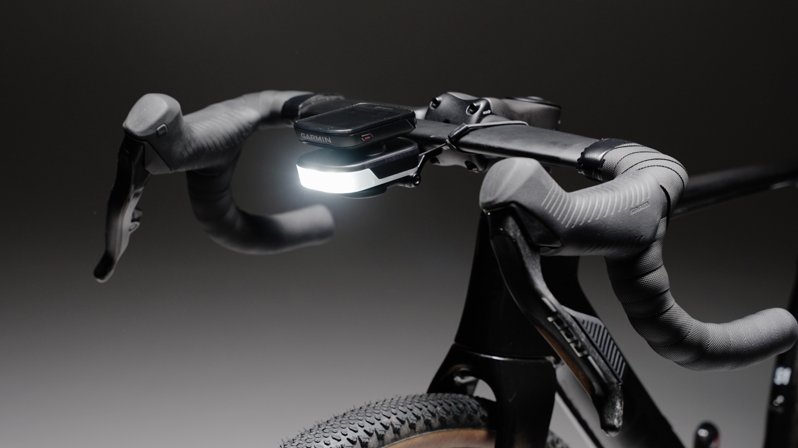 BBB Slice 600i Bike light mounted under neath the out-front computer mount, which intern is mounted to a gravel bike. Visible in the foreground is also the SRAM shifter and the bike integrated cockpit