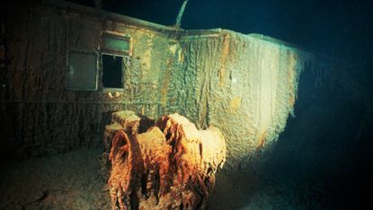 Titanic shipwreck on ocean floor lit by searchlights