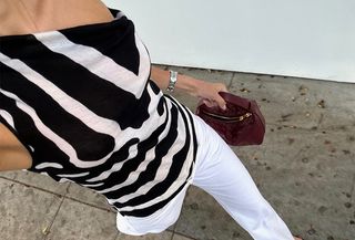 Woman wearing a zebra top and jeans.