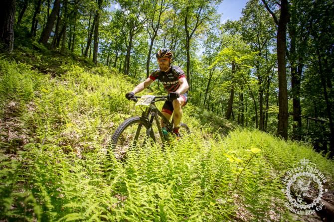 Thomas Turner pedals through the ferns on the downhill trail off of the ridge