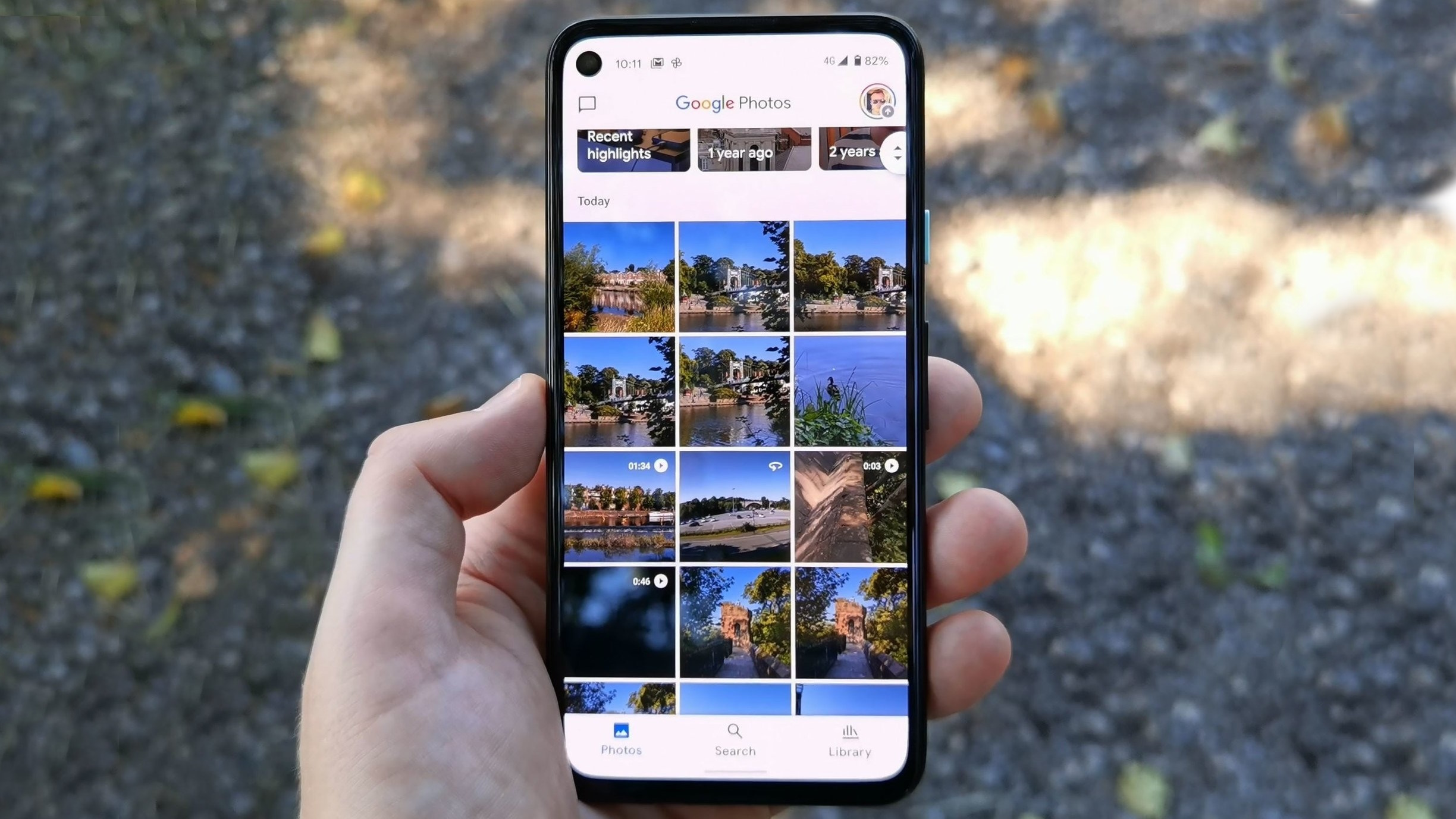 تطبيق صور Google على هاتف Pixel 4a يتم حمله بيد واحدة في الهواء الطلق.