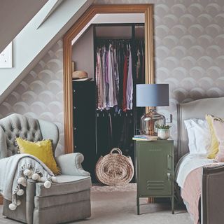 A bedroom covered in a patterned grey-tone wallpaper with a walk-in wardrobe