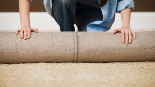woman rolling up a jute rug