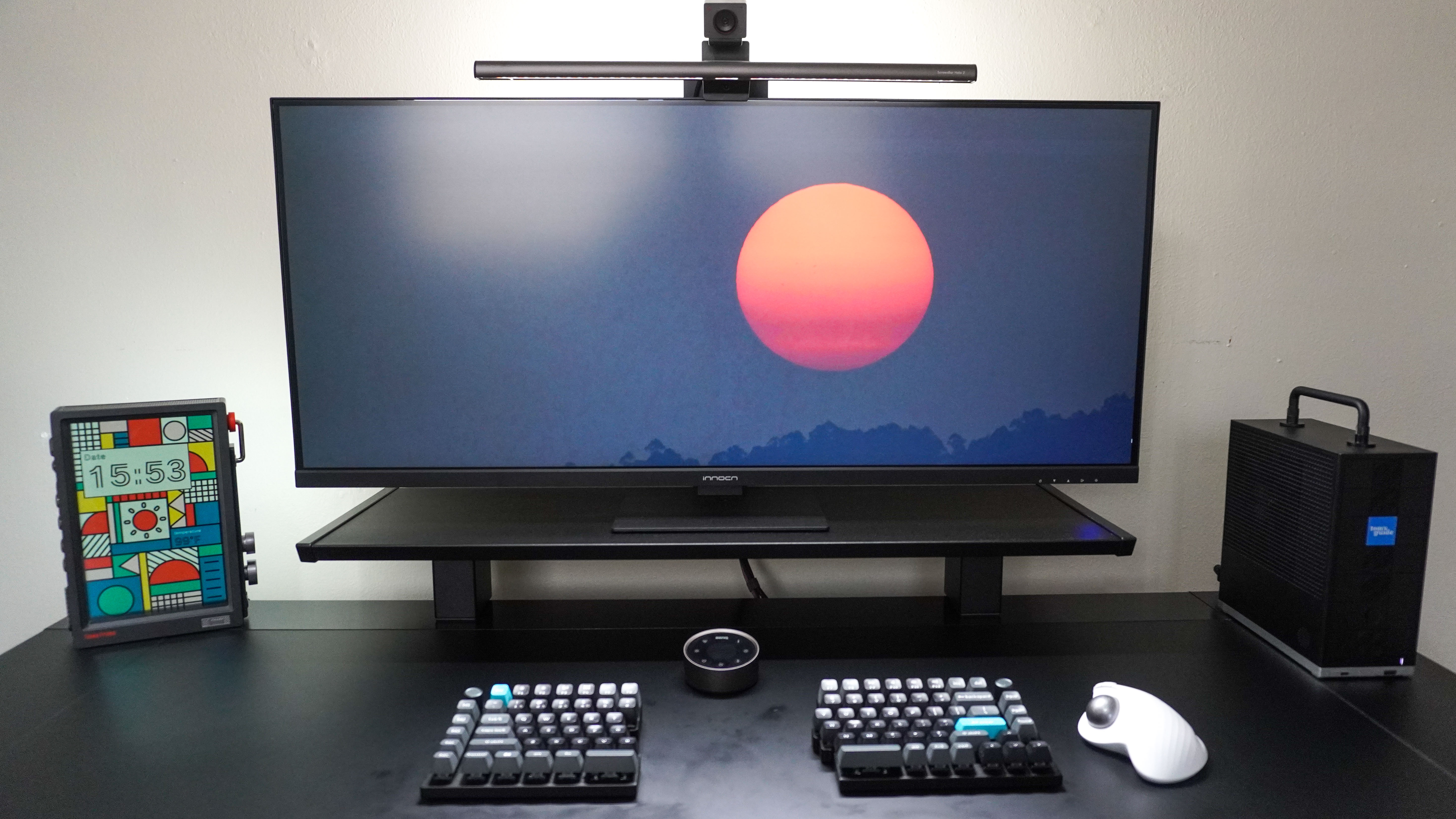 A wide shot of a desk setup with the Divoom Times Frame on the left side