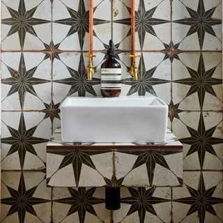 bathroom with monochrome tiles wash basin and tap
