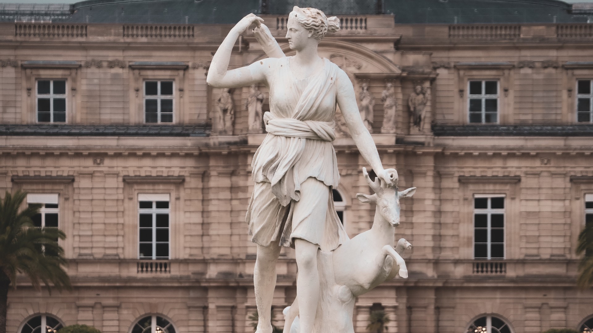 تمثال أبيض لشخصية أنثى ترتدي توغا وتحمل جعبة من السهام، وتضع يدها على رأس غزال