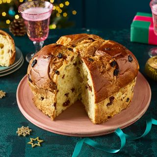 Morrisons The Best Panettone on a terracotta plate with a pink glass and blue background like a party