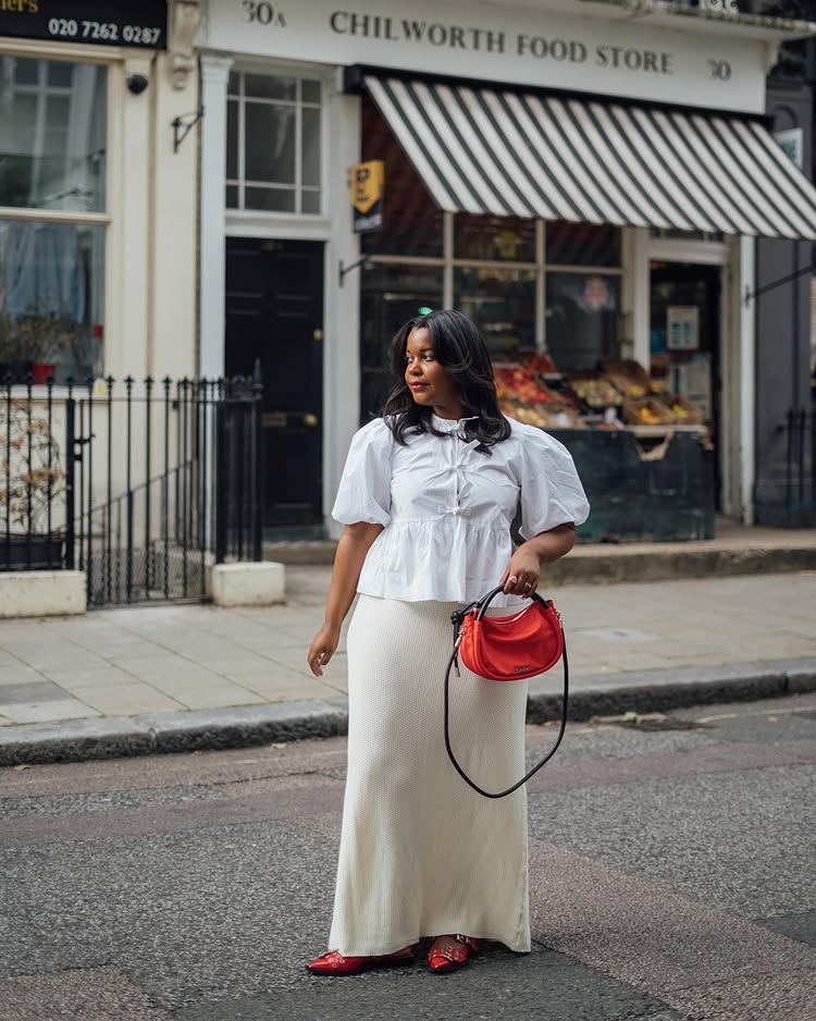 @styleidealist wears a cream maxi slip skirt with a white puff sleeve blouse and red accessories