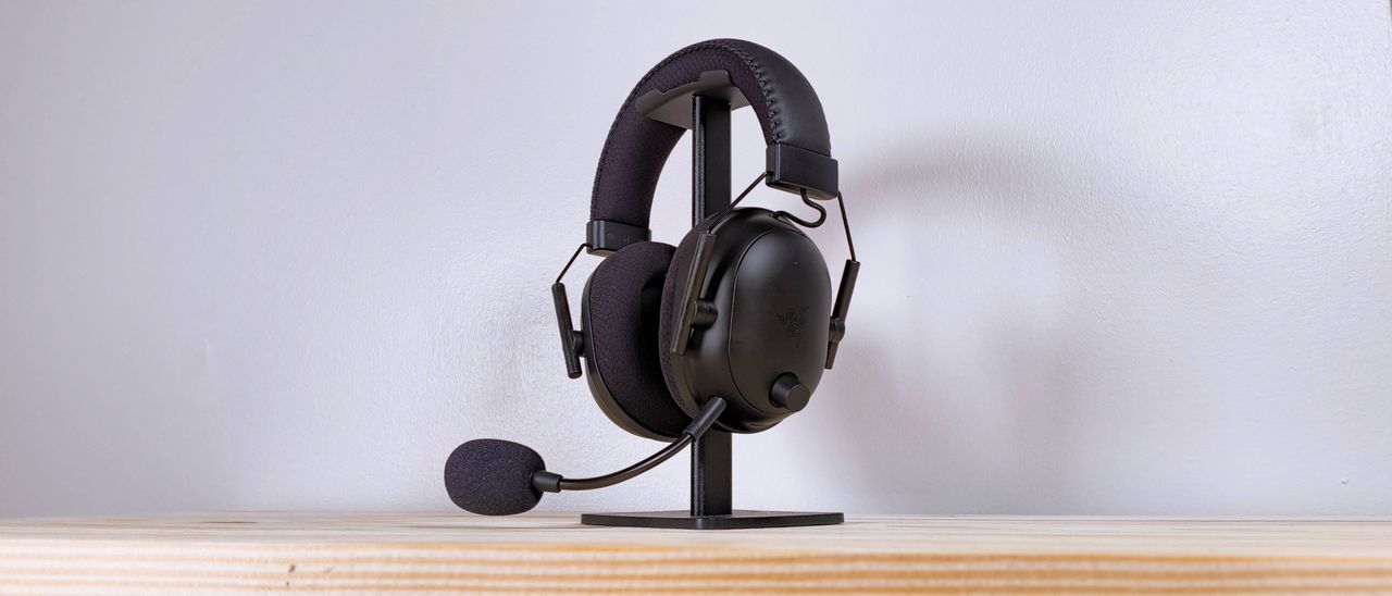 The Razer BlackShark V2 Pro headset in black on a stand on a wood table