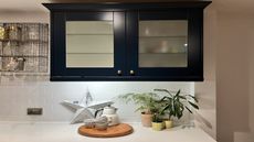Navy kitchen cabinet with white splashback and LED lighting