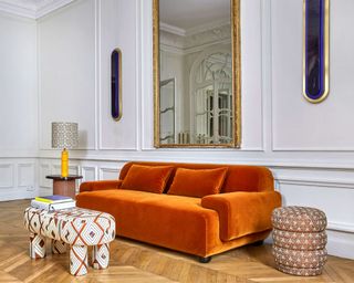Popus chunky orange sofa on parquet flooring with panelled walls and large mirror