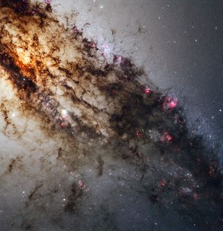 This new image, taken by NASA's Hubble Space Telescope, reveals never-before-seen details of the galaxy Centaurus A. The image is a composite, showing features in the visible, ultraviolet and near-infrared spectrum. 