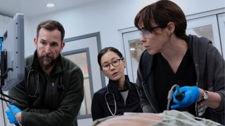 A team of doctors perform surgery on a torso