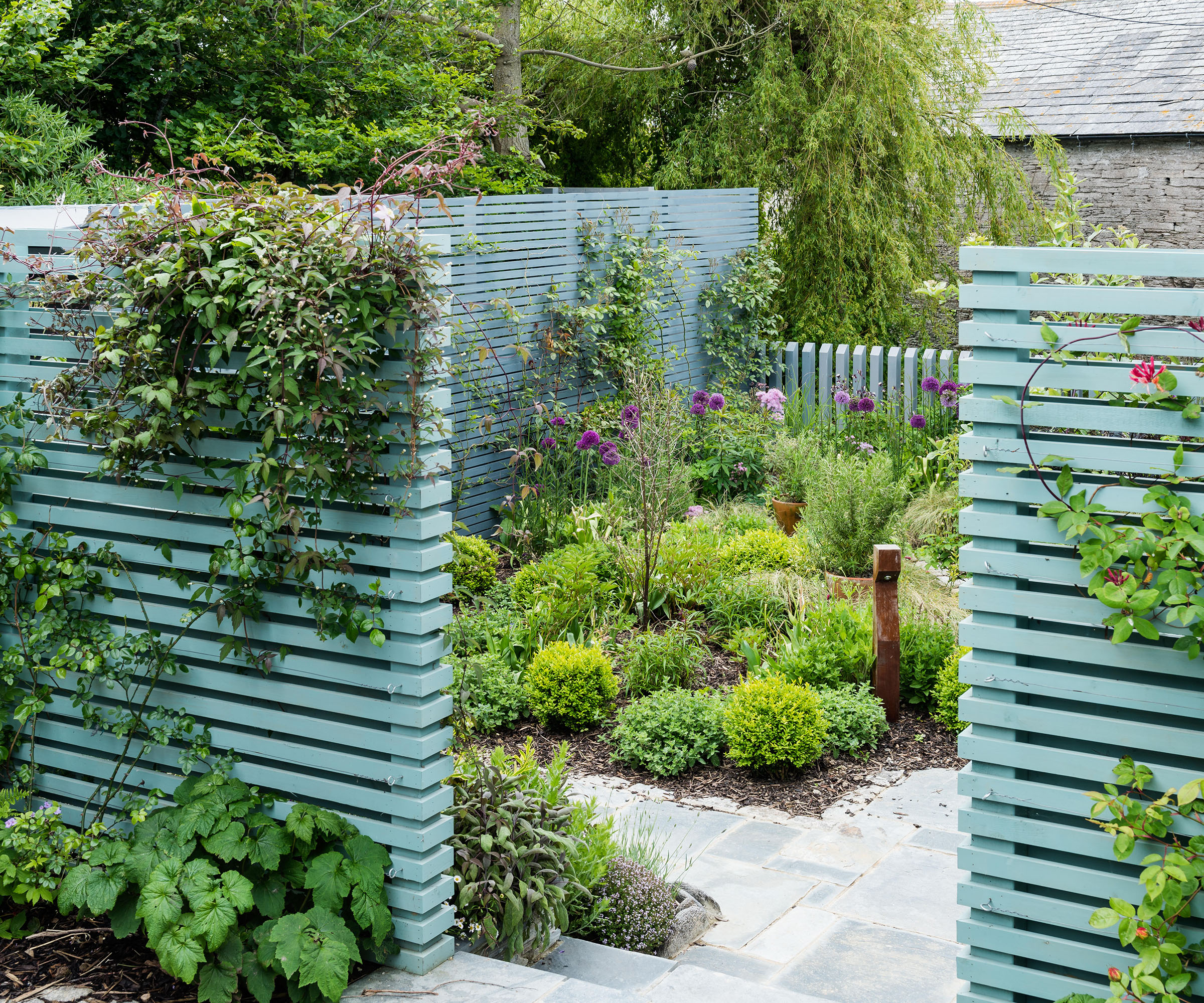 Courtyard garden with wooden slat screen painted in Pigeon from Farrow & Ball
