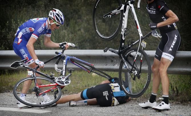 Geraint Thomas remains on the ground as others pick up their bikes