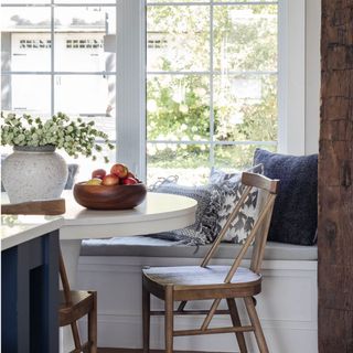 Small dining nook next to window with trad wooden dining chair and fruit bowl atop